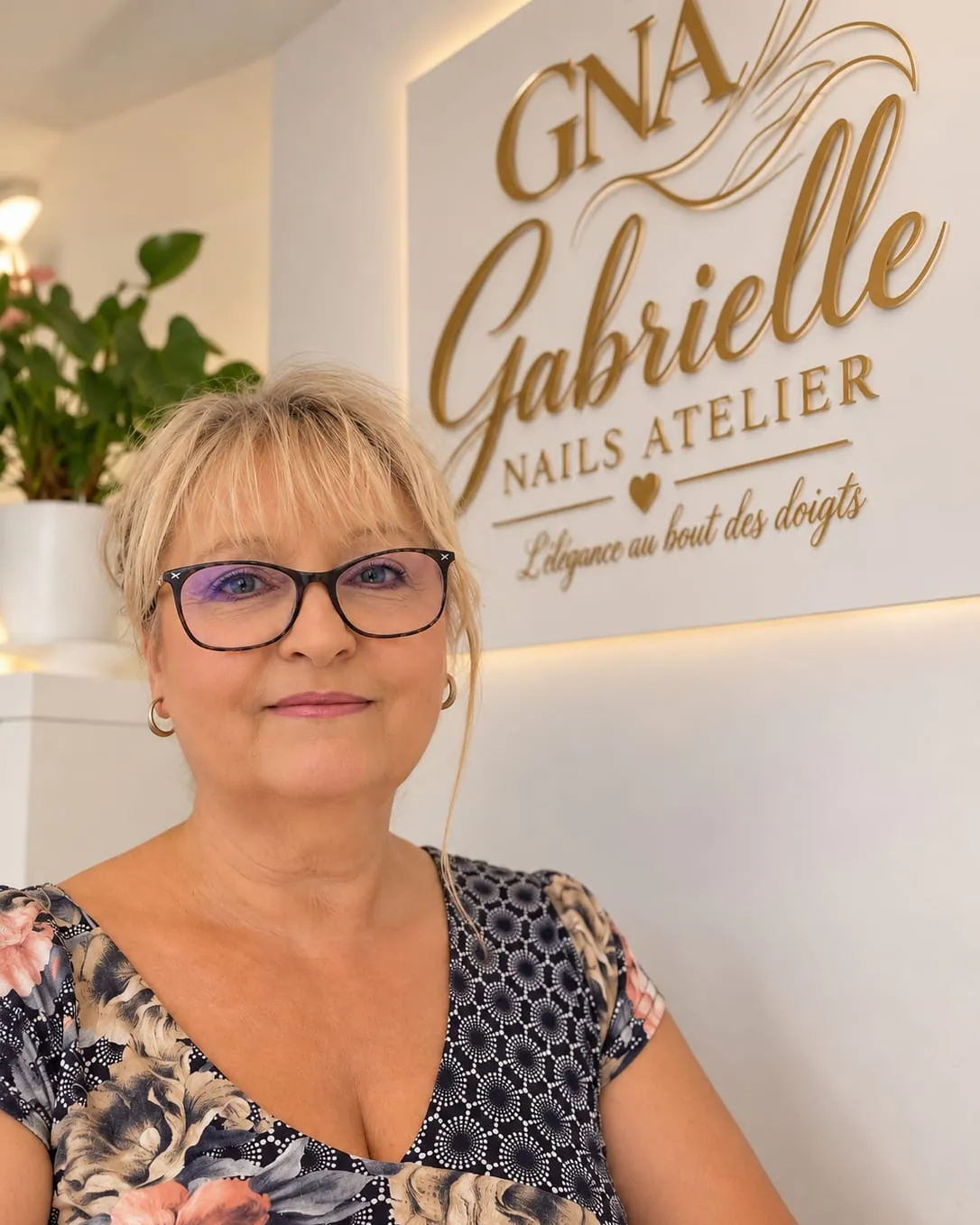 Gabrielle, fondatrice de Gabrielle Nails Atelier, devant l’enseigne dorée de l’atelier
